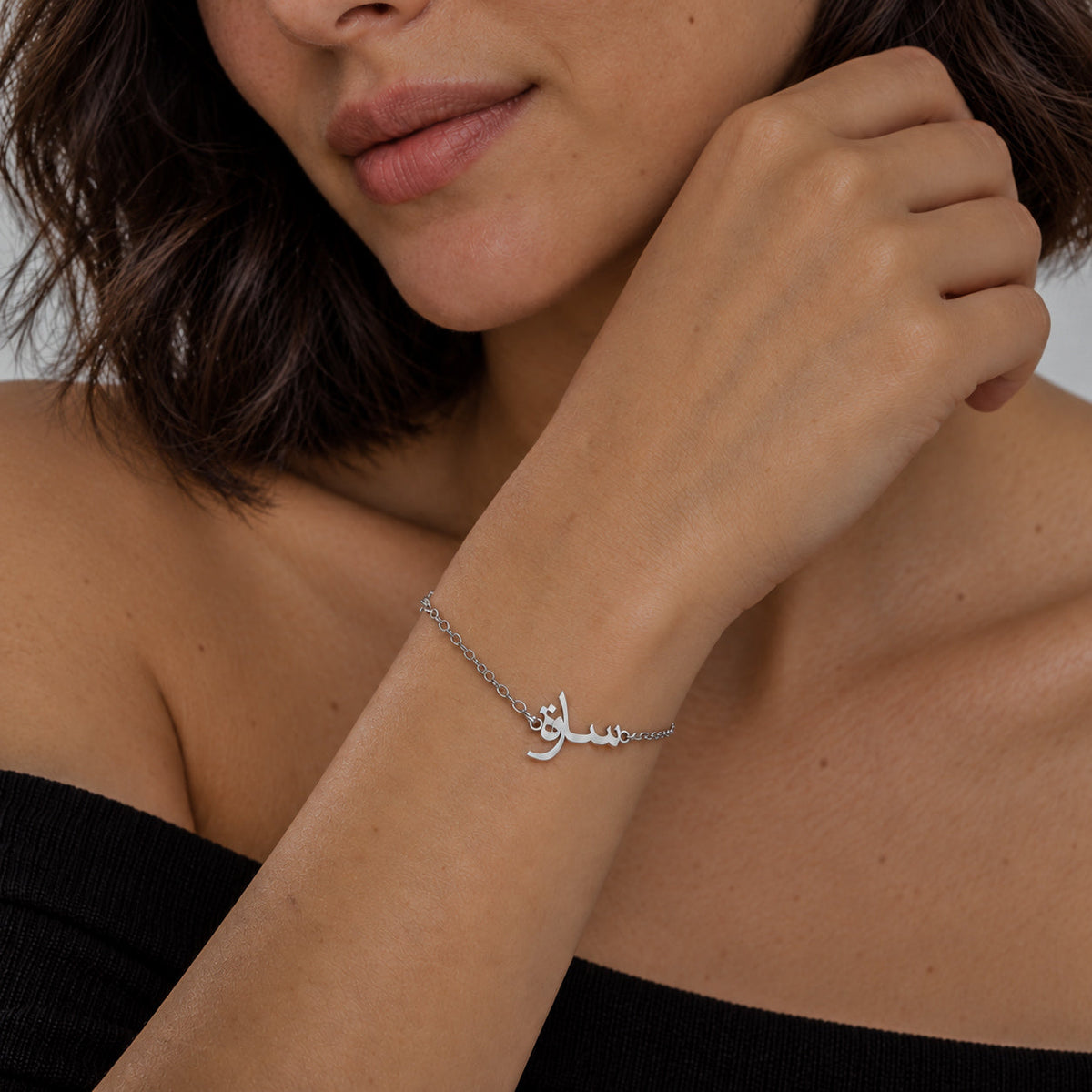 Bracelet avec prénom arabe couleur argent porté au poignet
